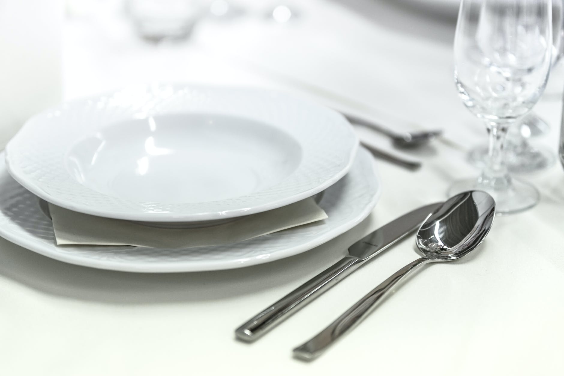 round white ceramic bowl placed on table beside wine glass