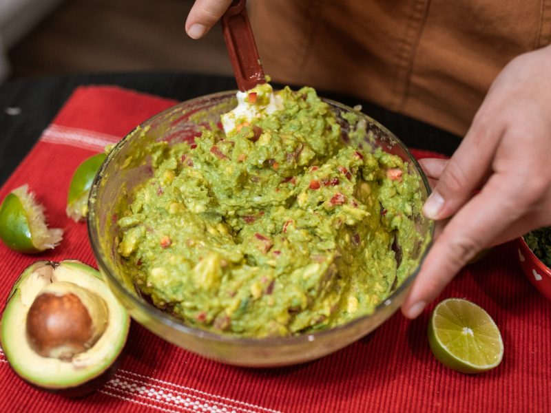 person making guacamole