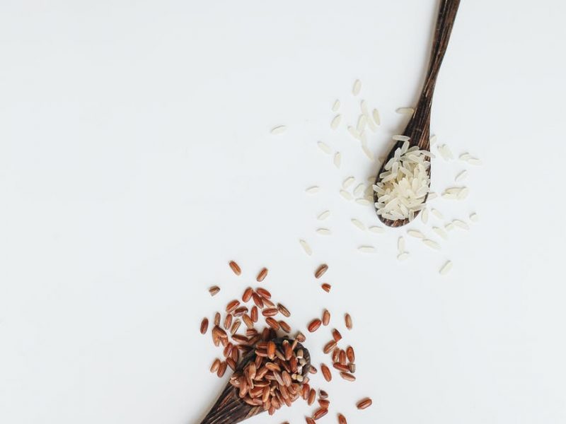 photo of assorted rice grain on wooden spoon